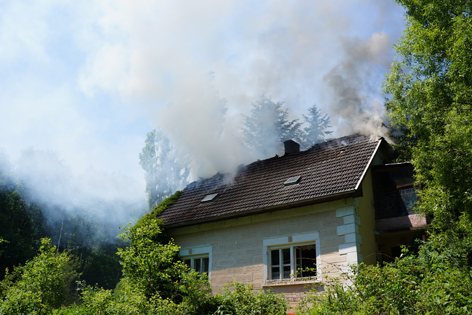 Rauch steigt aus dem Dachstuhl eines Hauses