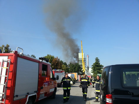 rauchender Turm aus der Ferne, Feuerwehr im Vordergrund
