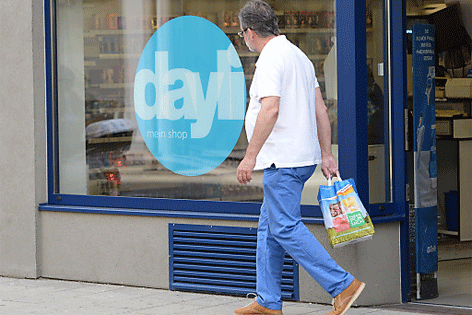 Mann geht mit Einkaufssackerl an dayli-Geschäft vorbei