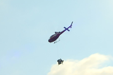 Hubschrauber in der Luft mit Abwurfbehälter