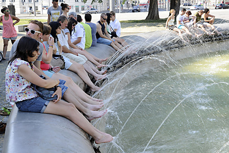 Menschen halten Beine in einen Brunnen