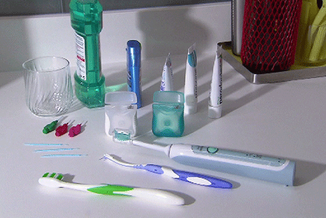 verschiedene Zahnpflegeprodukte, wie Zahnbürste, Zahnseide, Mundwasser