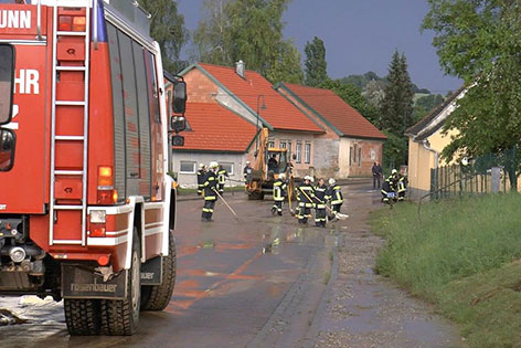 Feuerwehr beseitigt Schlamm mit Traktor von der Straße