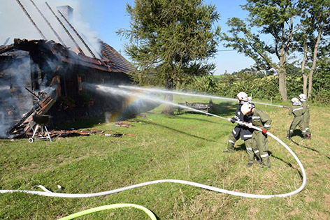Feuerwehrmänner bei Löscharbeiten bei einem Wohnhausbrand in Zöbern