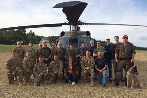 Amerikanische und österreichische Soldaten im Gruppenfoto vor dem reparierten Hubschrauber
