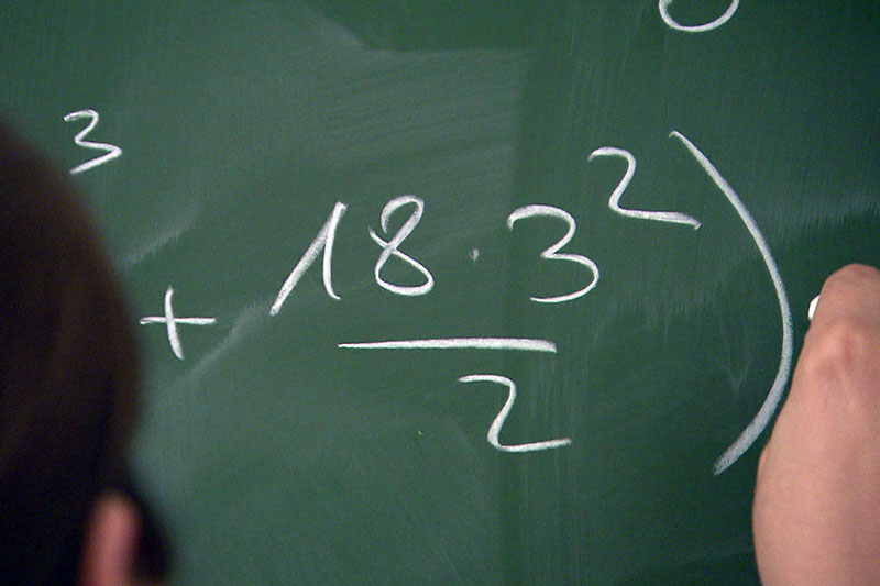 Mathematik Formel wird auf Tafel mit Kreide aufgeschrieben