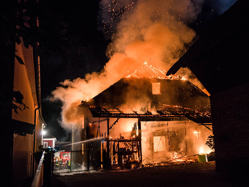 Einsatzkräfte löschen brennendes Haus