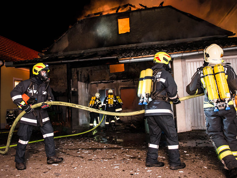 Einsatzkräfte löschen brennendes Haus
